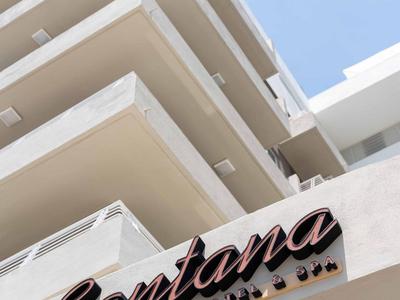 Modernes Hotelgebäude mit markantem Santana-Schild vor klarem Himmel.