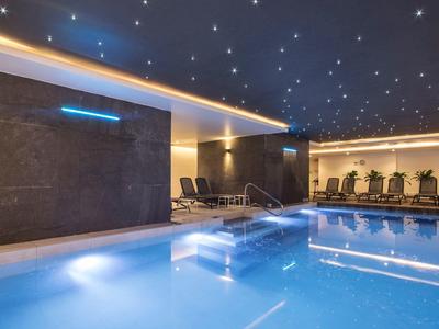 Binnenzwembad met een ontspannen sfeer, sfeerverlichting en ligstoelen