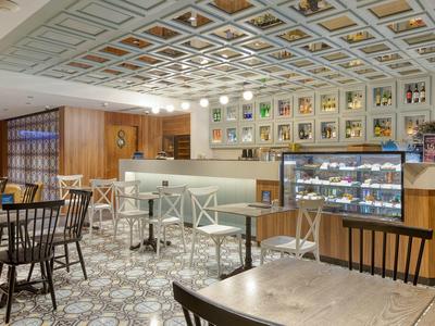 Modern café met lichte meubels, toonbank en versierde muren.