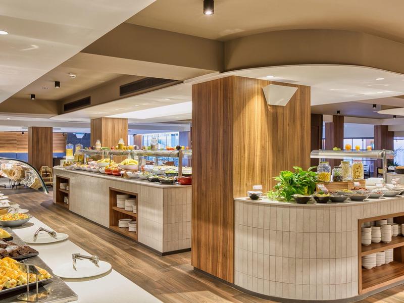 Moderne hotelbuffet met diverse gerechten en een gezellige houten inrichting.