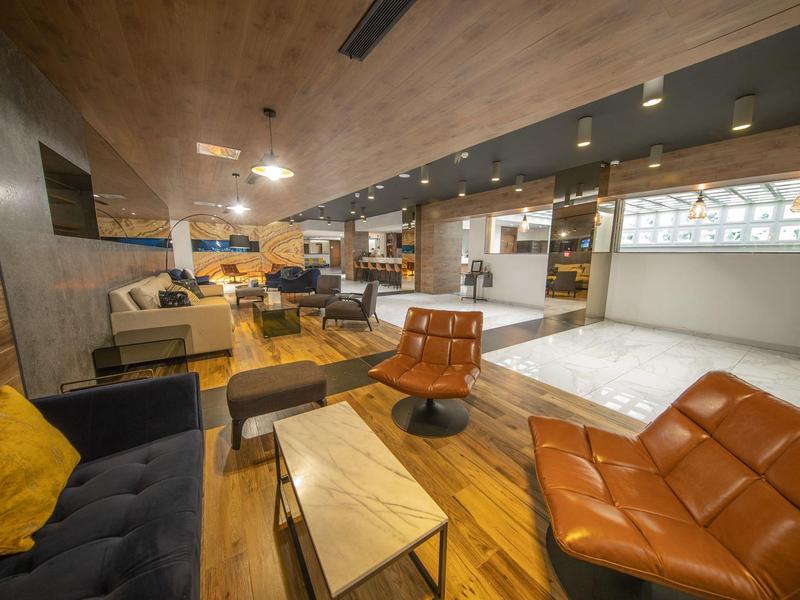 Moderne open hotel lounge met verschillende zitplaatsen en houten vloer