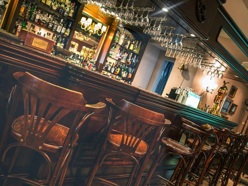 Gemütliche Bar mit Holzmöbeln und einer gut bestückten Getränketheke.