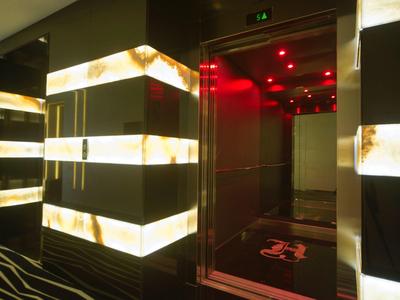 Nowoczesna winda z podświetlanymi ścianami i czerwoną iluminacją w hotelu.