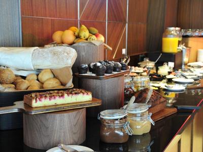 Bufet z bułeczkami, ciastem, dżemem i sokiem pomarańczowym w restauracji hotelowej.