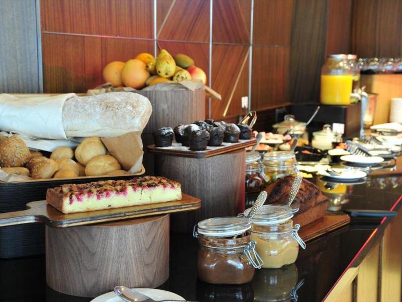 Bufet z bułeczkami, ciastem, dżemem i sokiem pomarańczowym w restauracji hotelowej.