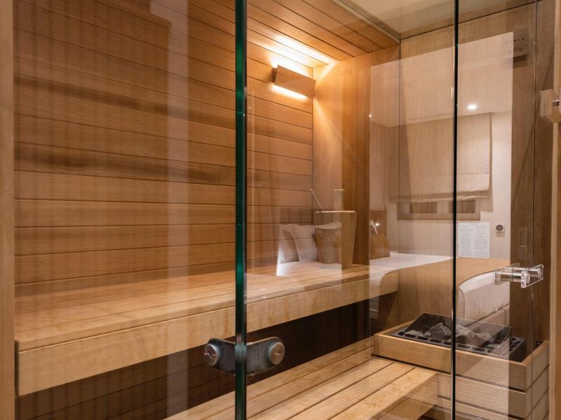 Interiér dřevěné sauny s lavičkou a řízeným osvětlením.