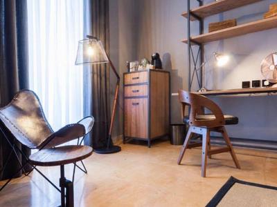 Nowoczesna część pokoju hotelowego z krzesłem, biurkiem, półkami i beżową podłogą