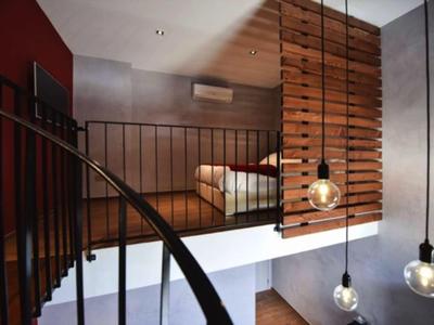 Modernes Hotelzimmer mit offenem Loft-Design, Holzakzenten und stilvollen Pendelleuchten.