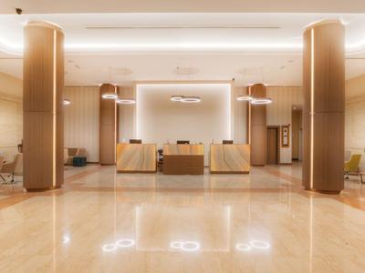 Großer, heller Hotellobby-Bereich mit hellem Marmorboden und Empfangstheke.