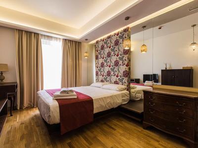 Gemütliches Hotelzimmer mit Holzfußboden, Doppelbett und eleganter Beleuchtung.