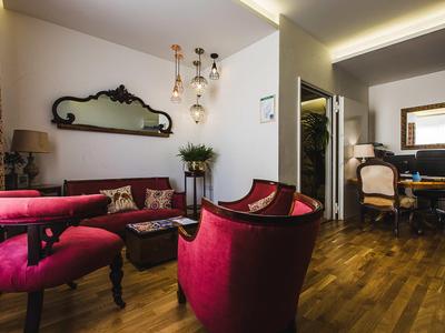 Elegantes Hotelzimmer mit roten Samtmöbeln, Holzboden und klassischem Design.