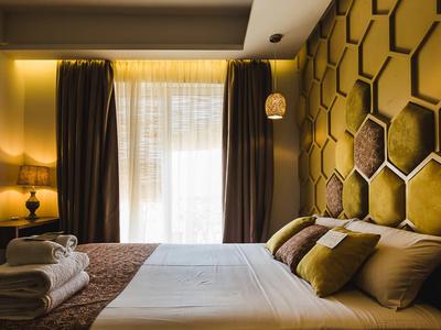 Gemütliches Hotelzimmer mit Bett, Kissen und dekorativer Wabenwandbeleuchtung.