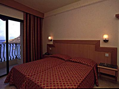 Gemütliches Hotelzimmer mit Zugang zum Balkon und Meerblick.