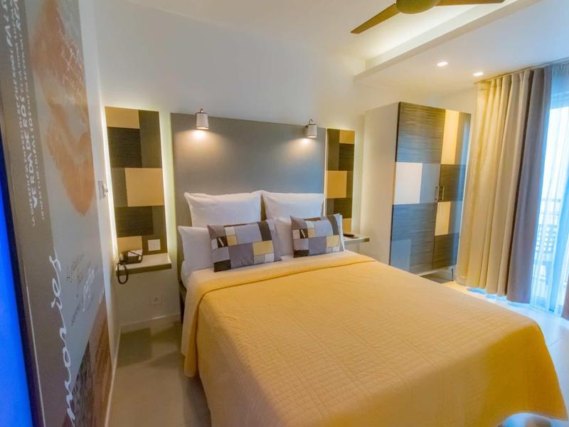 Nowoczesny pokój hotelowy z dużym łóżkiem, delikatnym oświetleniem i dużym oknem.