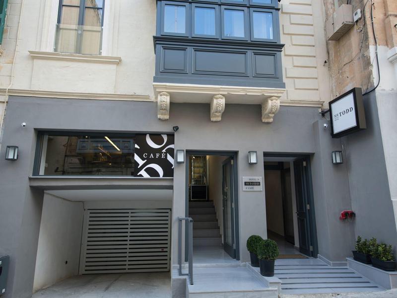 Entrée moderne d'un hôtel avec escalier et design urbain.