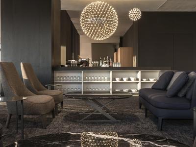 Moderne hotellounge met stijlvolle fauteuils, bank en decoratieve kroonluchters.
