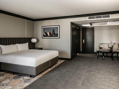 Modern eingerichtetes Hotelzimmer mit großem Bett und gemütlichem Sitzbereich