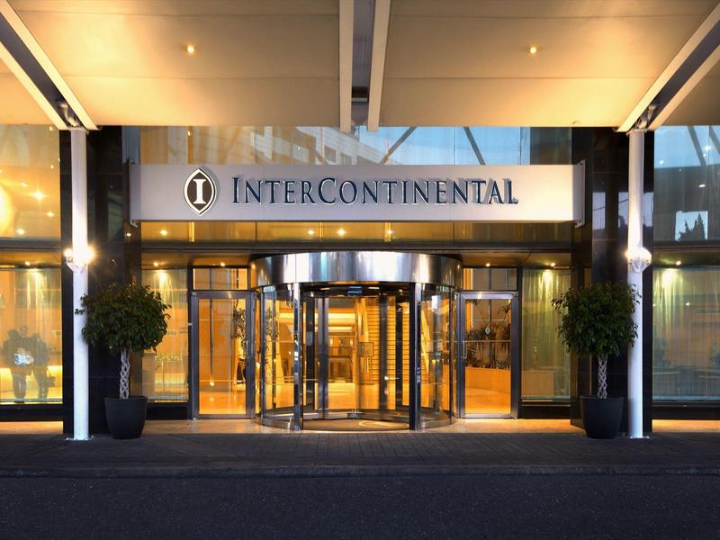 Eingang eines Hotels mit drehbarer Glastür und beleuchtetem Intercontinental-Schild.