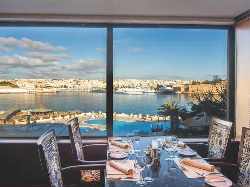 Widok na port i morze przez duże okno eleganckiej restauracji.