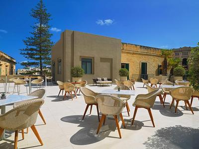 Buitenterras met moderne stoelen voor mediterrane gebouwen onder een helderblauwe lucht