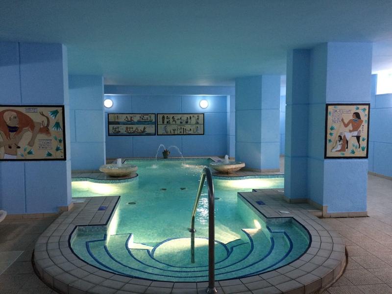 Vnitřní prostor s osvětleným vířivým bazénem v relaxačním spa prostředí