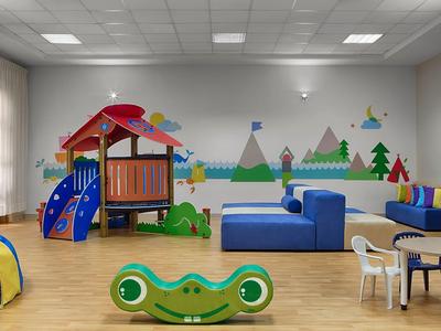 Kinderspielzimmer mit Klettergerüst, blauem Sofa, bunten Wandbildern und Spielzeug.