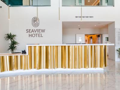 Modern hotel reception with gold accents and white design at Seaview Hotel.