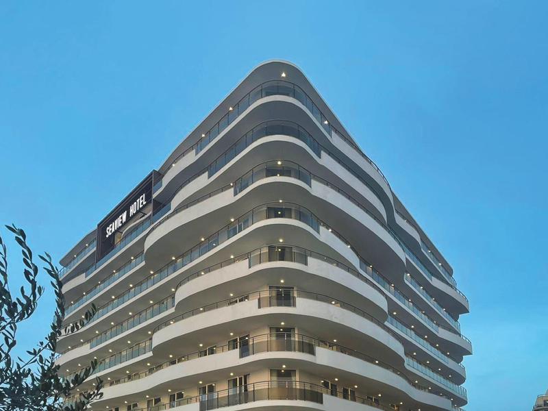 Moderní hotelová budova s oblými balkony za soumraku pod modrou oblohou