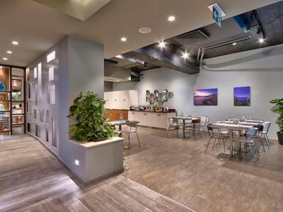 Moderner Hotelloungebereich mit Pflanzen, Kunstwerken und Sitzgelegenheiten.