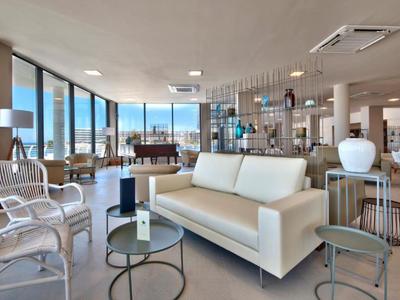 Modernes Lounge-Bereich mit Sofas und Sesseln, großflächigen Fenstern und Meerblick.