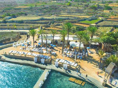 Strandabschnitt mit Sonnenschirmen und Liegestühlen an klarem, türkisfarbenem Wasser