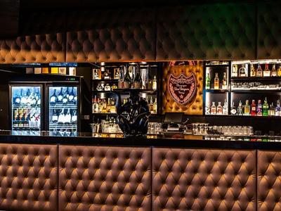 Bar area with LED lighting, refrigerated drink coolers, and elegant upholstery