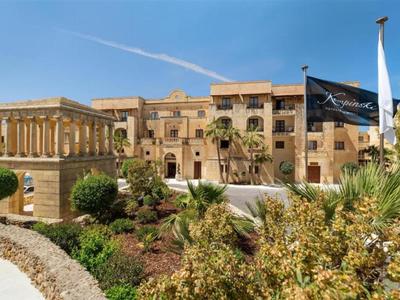 Hotelgebäude im mediterranen Stil mit Garten und blauem Himmel im Hintergrund