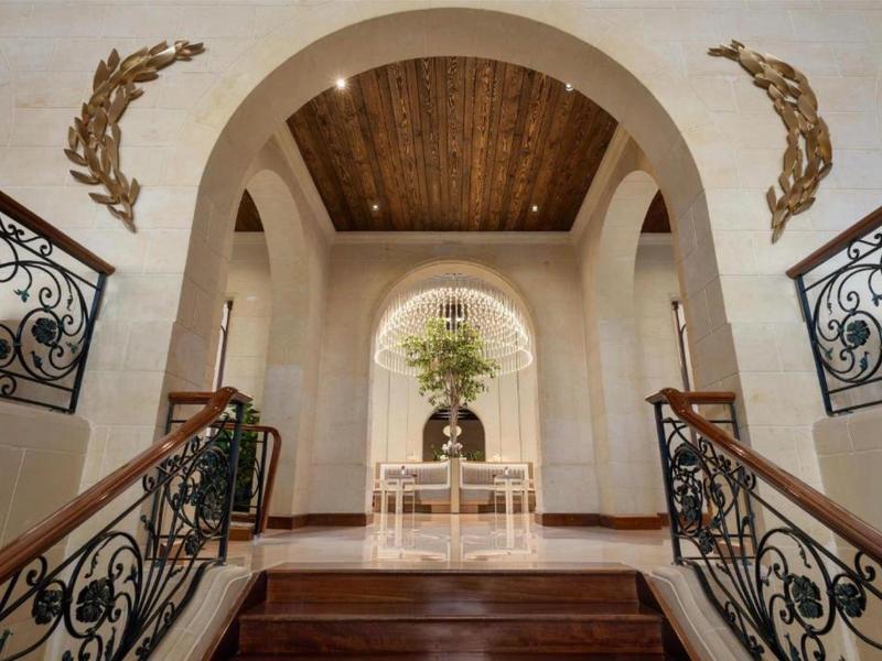 Elegantní vstupní prostor s dřevěným stropem, schody a dekorativními kovanými zábradlími