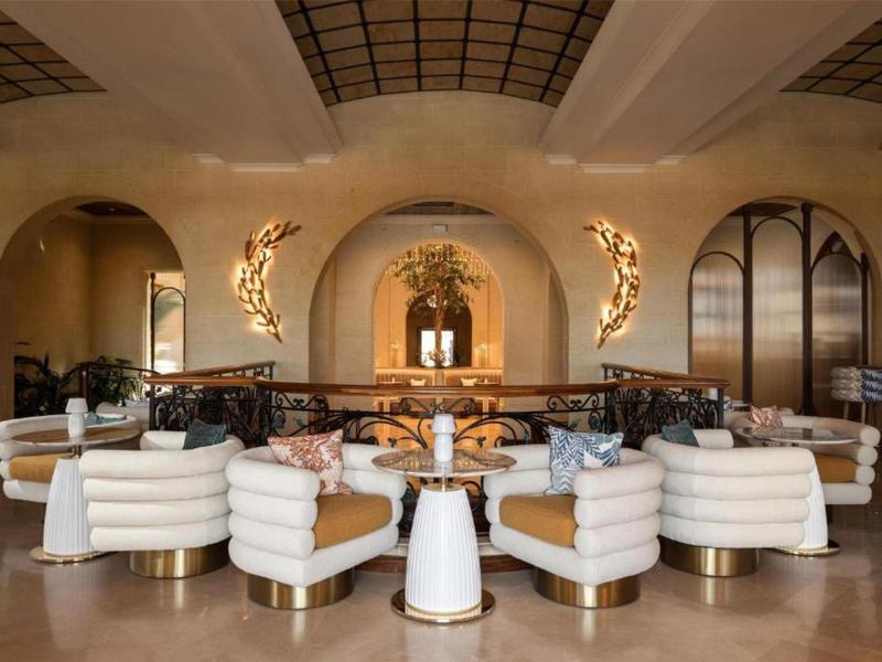 Elegantní hotelová lobby s pohodlnými bílými křesly a útulným osvětlením.