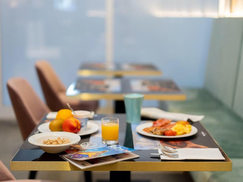 Een gedekte ontbijttafel met sap, fruit en servies in een moderne eetruimte.