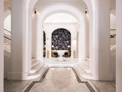 Elegante Hotellobby mit hohen Bögen, Marmorboden und modernen Sitzbereichen.