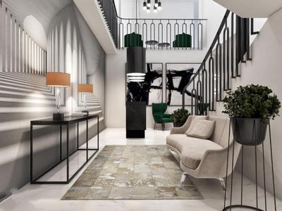 Área de entrada moderna con escalera, sillones, alfombra y plantas decorativas en tonos neutros.