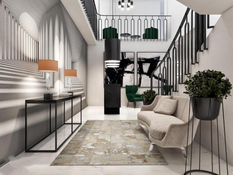 Bright, modern hotel lobby with staircase, seating, plants, and minimalist decor.