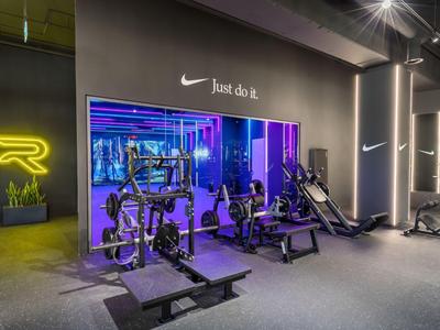 Gimnasio moderno con varias máquinas y luces de neón en un hotel.