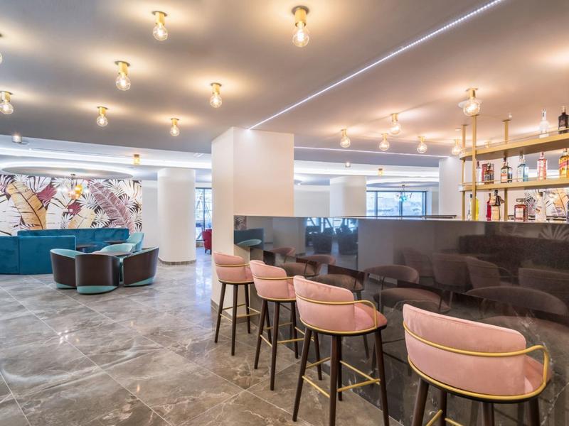 Espace bar d'hôtel moderne avec sièges élégants et éclairage lumineux.