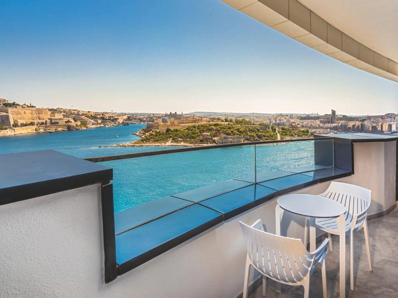 Balcon avec vue sur la mer et la ville par temps clair.