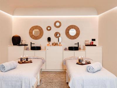 Sala de spa moderna con dos camillas de masaje y círculos decorativos en la pared.