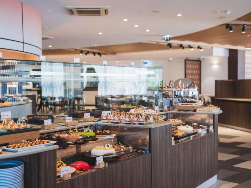 Área de buffet en un restaurante de hotel moderno con varios platos y diseño elegante.