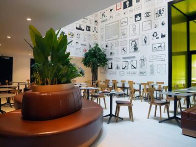 Moderner Speiseraum mit braunen Ledersitzen, Holzstühlen und einer Wand mit vielen Kunstdrucken.