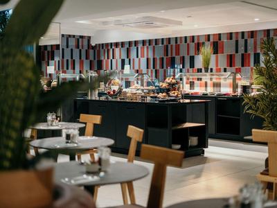 Ristorante moderno con piastrelle colorate, mobili in legno e area buffet