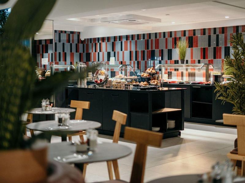 Ristorante moderno con piastrelle colorate, mobili in legno e area buffet