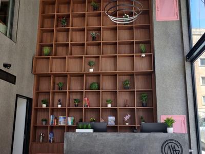 Moderner Hotel-Check-in mit grauem Tresen und Holzregalwand mit Dekoration