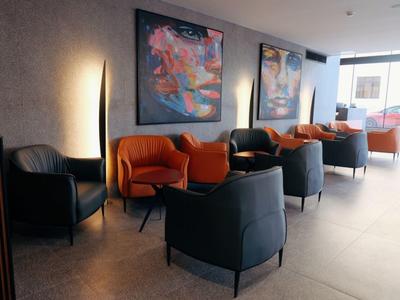 Moderner Wartebereich mit bunten Sesseln, Kunstwerken und natürlichem Licht