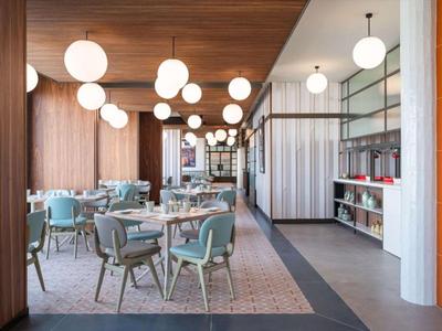 Dachterrasse mit Infinity-Pool, Liegestühlen und Ausblick auf die Stadt und das Meer.